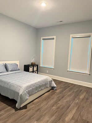 A bedroom with a bed, nightstands, and two windows with blinds. - Beautiful Escape, Mins from Carowinds & Lake Wylie (Charlotte)