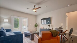 A modern living room with a sofa, coffee table, and dining area.