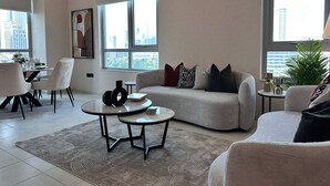 Un salon moderne avec un coin repas, de grandes fenêtres et une vue sur la ville.