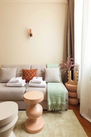 Una sala de estar moderna con un sofá, una mesa redonda y un jarrón decorativo.