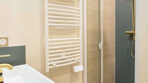 A modern bathroom with a large white sink, a gold showerhead, and a glass-enclosed shower. - Port-royal Residence-magnificent Apartment -1br-4p (Paris)