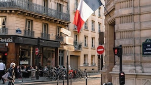A street scene with a café named 'Perla' and a flagpole with a flag. - Port-royal Residence-magnificent Apartment -1br-4p (Paris)