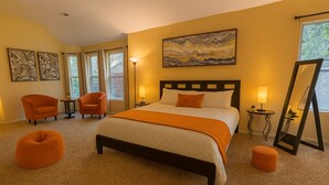 A hotel room with a large bed, two chairs, a small table, and a mirror. - Spacious Home Quiet Neighborhood nr Downtown (Carrollton)