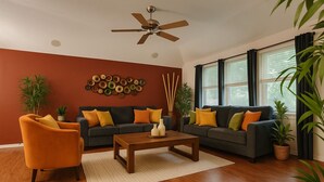 Un salon avec deux canapés, une table basse et un ventilateur de plafond.