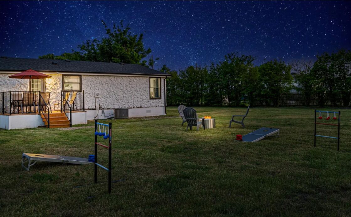 Une maison à l’extérieur en pierre, avec un porche abrité et un ciel étoilé.