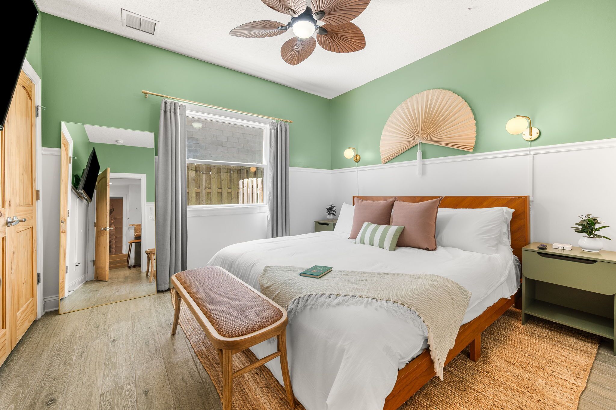 A bedroom with a bed, bedside table, and a ceiling fan.