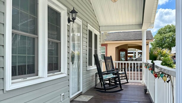 A covered porch with a ceiling fan, a rocking chair, and a white railing. - 5327 Ocean Lakes Pet Friendly Golf Cart⛱️🏝️🩱🌊👙☀️🐚 (Myrtle Beach)