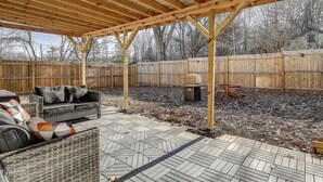 A covered patio area with a wooden pergola, outdoor furniture, and a fenced backyard. - No cleanup chores-Fenced yard, fire pit. Close to I81, downtown. Walk to casino. (Bristol)