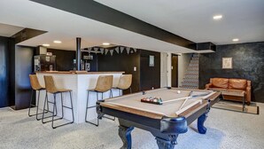 A pool table with chairs, a bar area, and a leather couch. - No cleanup chores-Fenced yard, fire pit. Close to I81, downtown. Walk to casino. (Bristol)