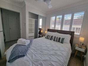 Tabla de planchar con plancha, cuna de viaje y ropa de cama 