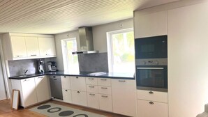 Eine moderne Küche mit weißen Schränken, einer schwarzen Arbeitsplatte und einem eingebauten Backofen.