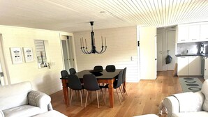 Ein modernes Wohnzimmer mit Esstisch, zwei Sofas und einer Kronleuchter.