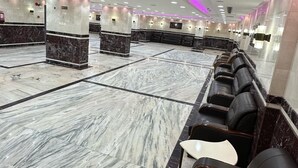 A spacious lobby with marble flooring, black leather seating, and purple ambient lighting. - Mashrab Riwa Almansour Hotel (Makkah)