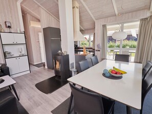 Una cocina moderna con una isla central, una mesa de comedor con sillas y vistas al exterior.