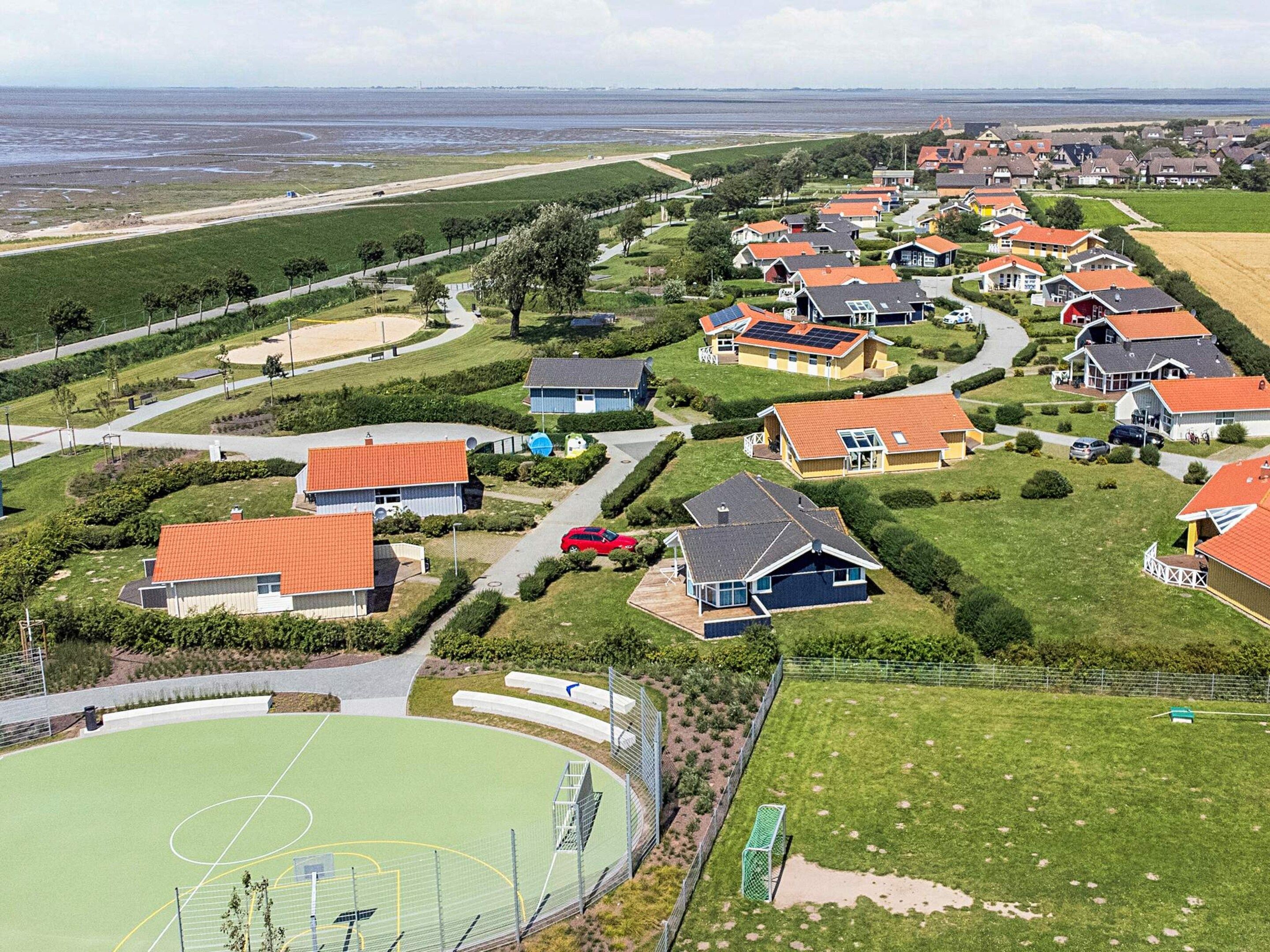 A residential area with houses, a sports field, and a road.