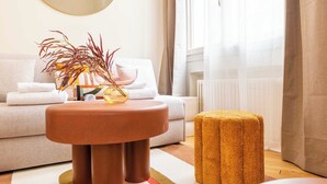 A modern living room with a round table, a small stool, and a sofa. - Port-royal Residence - Modern Apartement-1br- 4P (Paris)