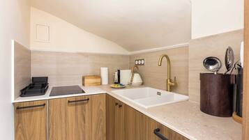 Appartement | Privékeuken | Een koelkast, een kookplaat, een vaatwasser, kookgerei, borden en bestek