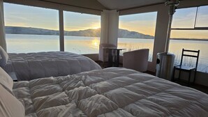 A bedroom with two beds and a view of a lake and mountains. - Uros Maya lodge (Puno)