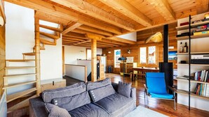 A wooden interior with a sofa, a blue chair, and a bookshelf. - Chalet, view mountain, fireplace or stove, parking, tv, ski locker, 125m², Vars (Vars)