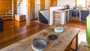 A spacious wooden interior with a high ceiling, a staircase, a kitchen area, and a dining table with bowls. - Chalet, view mountain, fireplace or stove, parking, tv, ski locker, 125m², Vars (Vars)