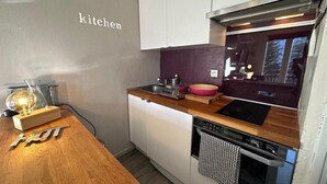 A compact kitchen with white cabinets, a wooden countertop, a stove, and a sink. - 1st floor, tv, ski locker, 23m², Vars (Vars)