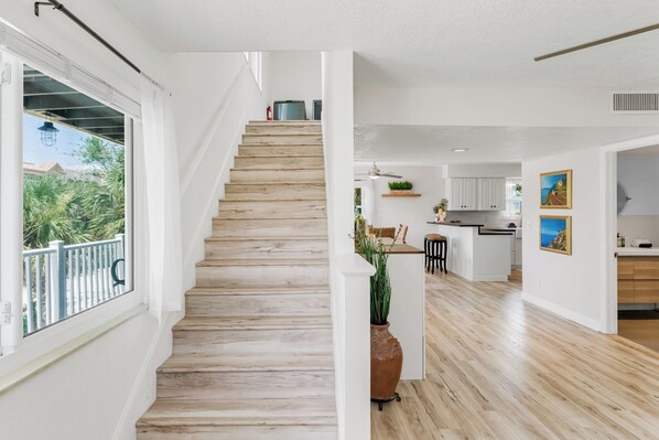 A staircase leading to a balcony with a view of greenery.