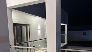 A modern building with a glass railing and a marble floor. - Alojamento Santos Silva  (São Tomé)