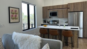 A modern kitchen with a central island, stainless steel appliances, and wooden cabinetry. - Lost Buck Resort - Modern home surrounded by native trees & beautiful view (Cedaredge)