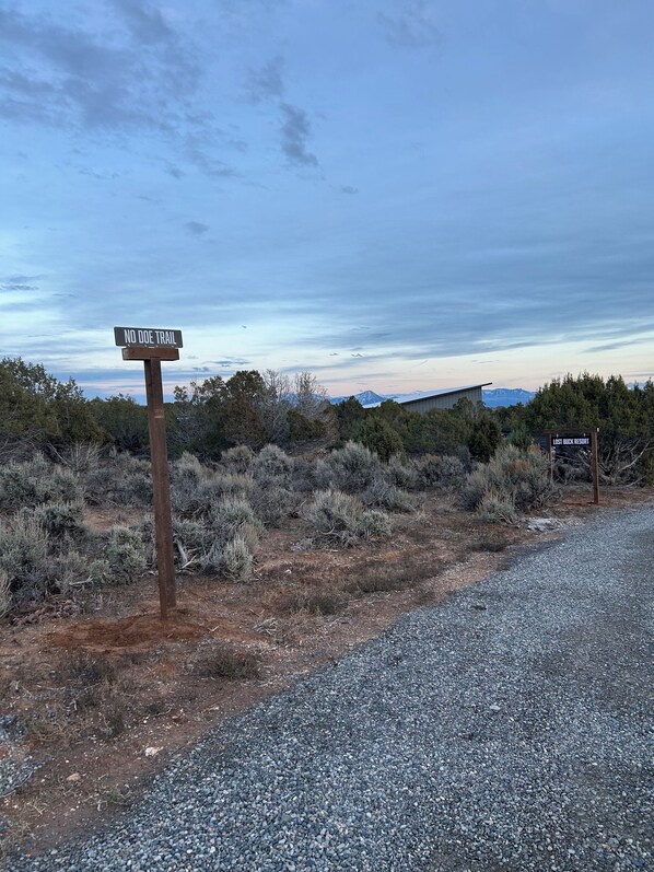 A sign indicating 'NO DOE TRAIL' and another sign for 'LOST BUCK RESORT'. - Lost Buck Resort - Modern home surrounded by native trees & beautiful view (Cedaredge)