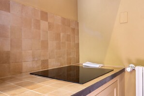 A bathroom with a black countertop, beige tiles, and a towel on the counter. - Renaissance Tower Apartment (Firenze)