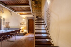 A modern interior with a staircase, a seating area with a sofa, and a lamp. - Renaissance Tower Apartment (Firenze)