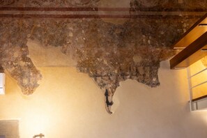 A room with a high ceiling featuring exposed stonework and a wooden beam structure. - Renaissance Tower Apartment (Firenze)