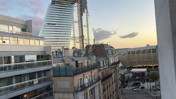 Un edificio de varios pisos con fachada de vidrio moderna y una grúa de construcción cerca, lo que indica desarrollo en curso.