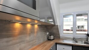 A modern kitchen with a built-in oven, a toaster, and a sink.