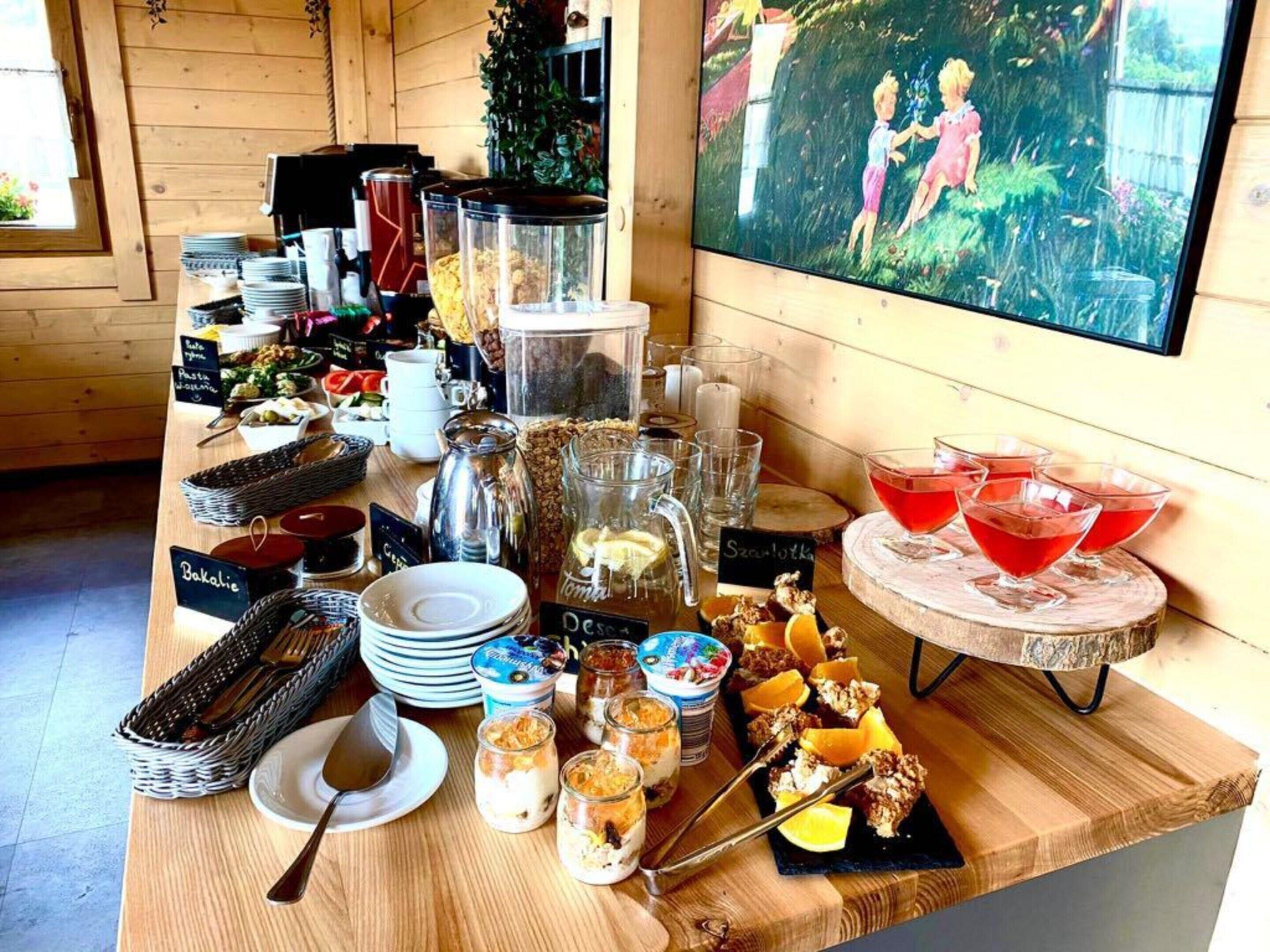 A breakfast buffet with various food items, drinks, and a television displaying a children's show.