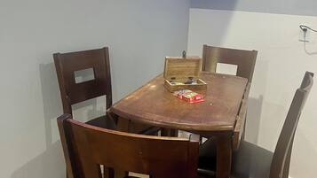 Ein Essbereich mit Holztisch und -stühlen, einem Bild an der Wand und blauen LED-Leuchtstreifen an der Decke.