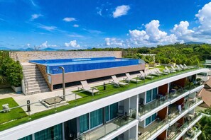A modern hotel with a rooftop pool, outdoor seating, and a view of the surrounding landscape. - Suite Solen 1br|pool View|rawai (Rawai)