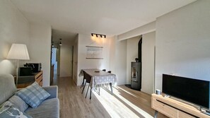 Una sala de estar moderna con un sofá, una mesa de comedor, un televisor y una chimenea.