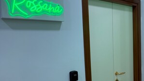 Une porte fermée, une clé dans la serrure et un panneau lumineux au néon au-dessus.