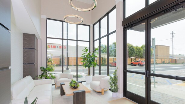A modern interior with a white sofa, armchairs, a coffee table, and potted plants. - Coastal Getaway with Ocean Views (Grover Beach)