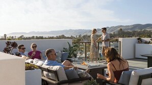 A rooftop terrace with outdoor seating, a fire feature, and a view of distant mountains. - Coastal Getaway with Ocean Views (Grover Beach)