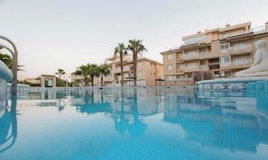 A swimming pool with a clear view of the surrounding buildings and palm trees.