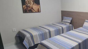 A bedroom with two beds, each with striped bedding. - Ape in the mountains (Caxias do Sul)