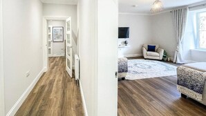 Een moderne woonkamer met een houten vloer, een bank, een salontafel en een televisie.