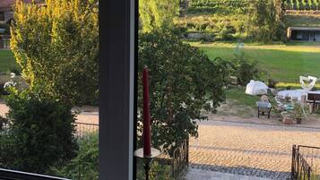 Vista desde la ventana de un viñedo con una vela roja en el alféizar.