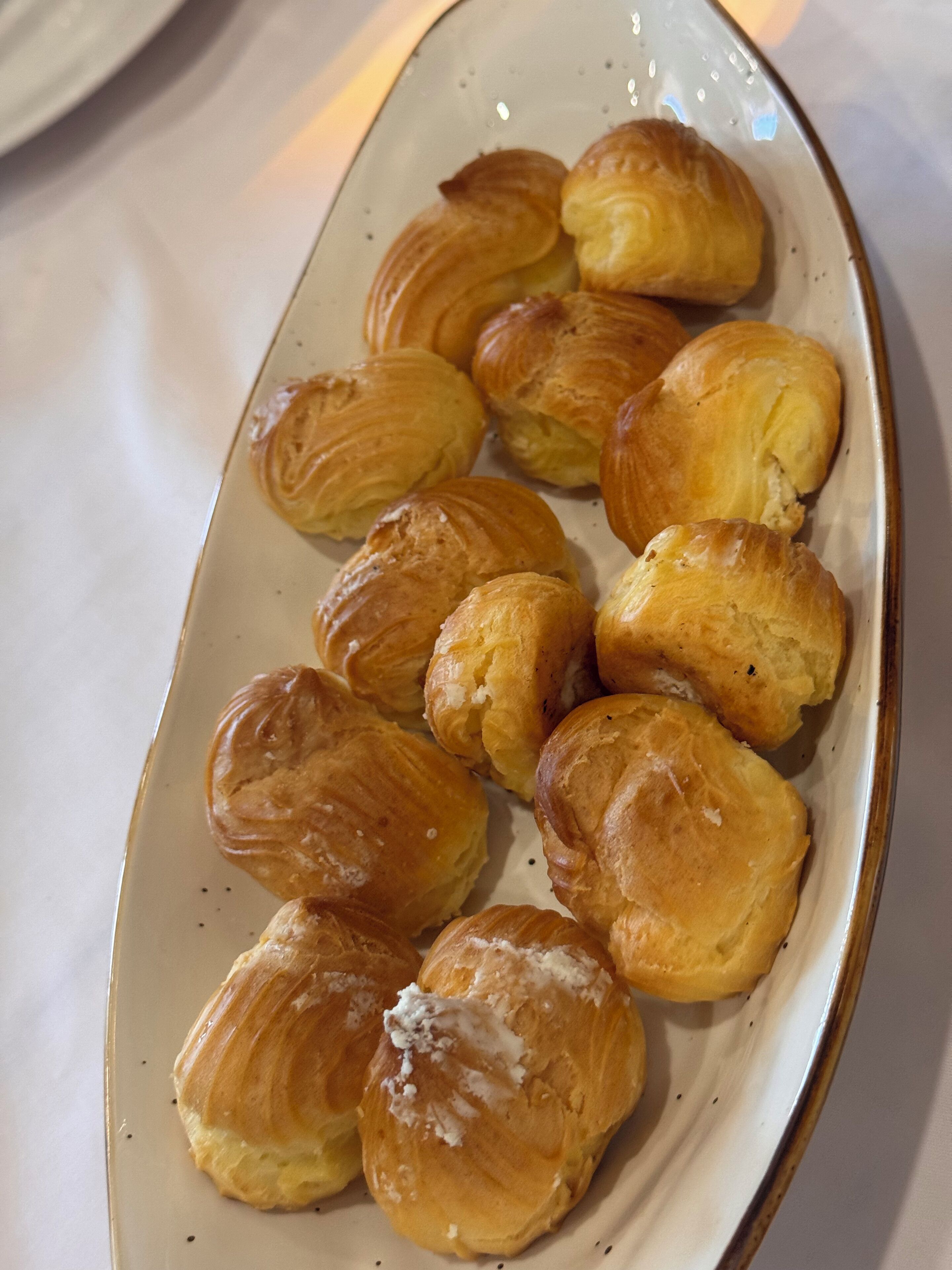 Un plat de pastissos daurats, probablement croissants, disposats sobre un plat de ceràmica.