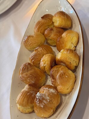 En tallrik med gyllenbruna bakverk, troligen croissanter, som är vackert upplagda på en keramiktallrik.