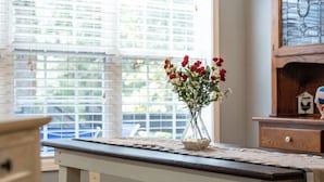 A kitchen with a white table, a bench, a chandelier, and a window with blinds. - Grove Hill - Spacious Home w/Hot Tub, 4 BRs, 4BAs, near downtown Dahlonega! (Dahlonega)