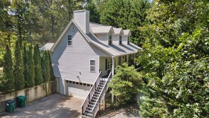 A two-story house with a covered porch and a staircase leading to the garage. - Grove Hill - Spacious Home w/Hot Tub, 4 BRs, 4BAs, near downtown Dahlonega! (Dahlonega)
