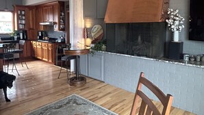 A modern kitchen with wooden cabinets, a central island, and a fireplace. - Luxury on the Lake (Storm Lake)